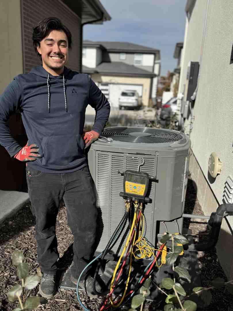 Heat pump repair technician working on outdoor unit - heat pump repair salt lake city ut