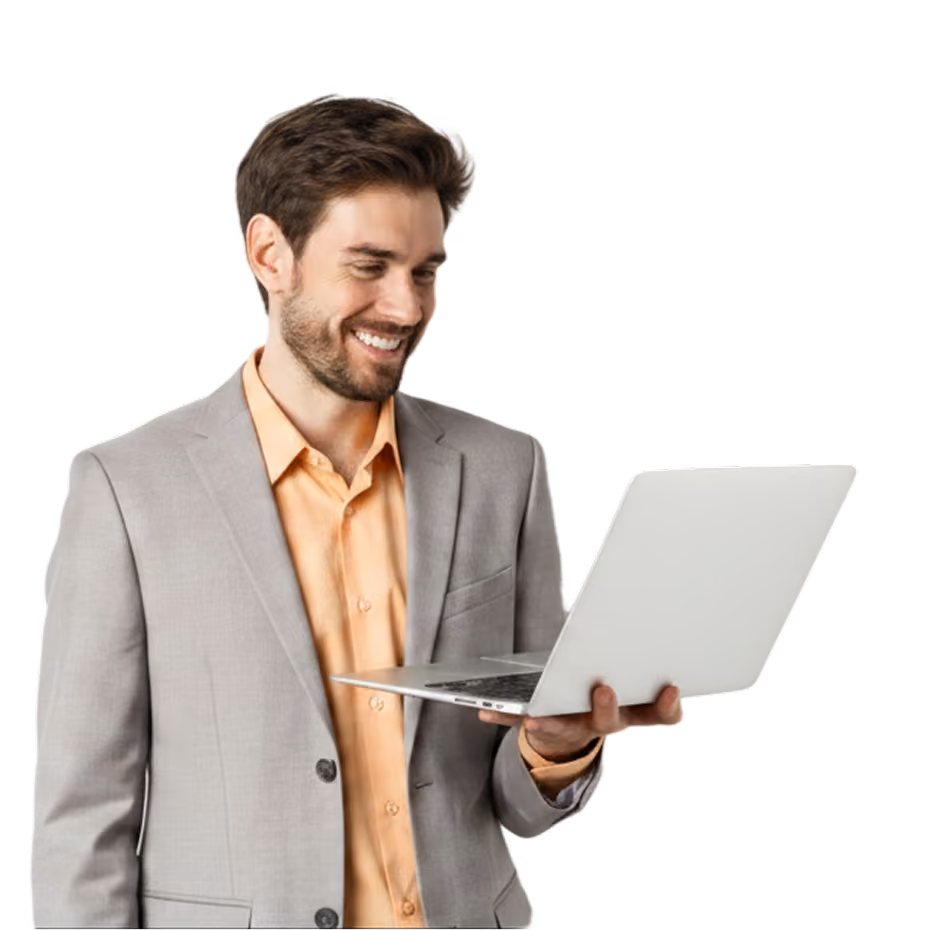 Hombre sonriente con traje mirando una laptop blanca que sostiene con una mano.
