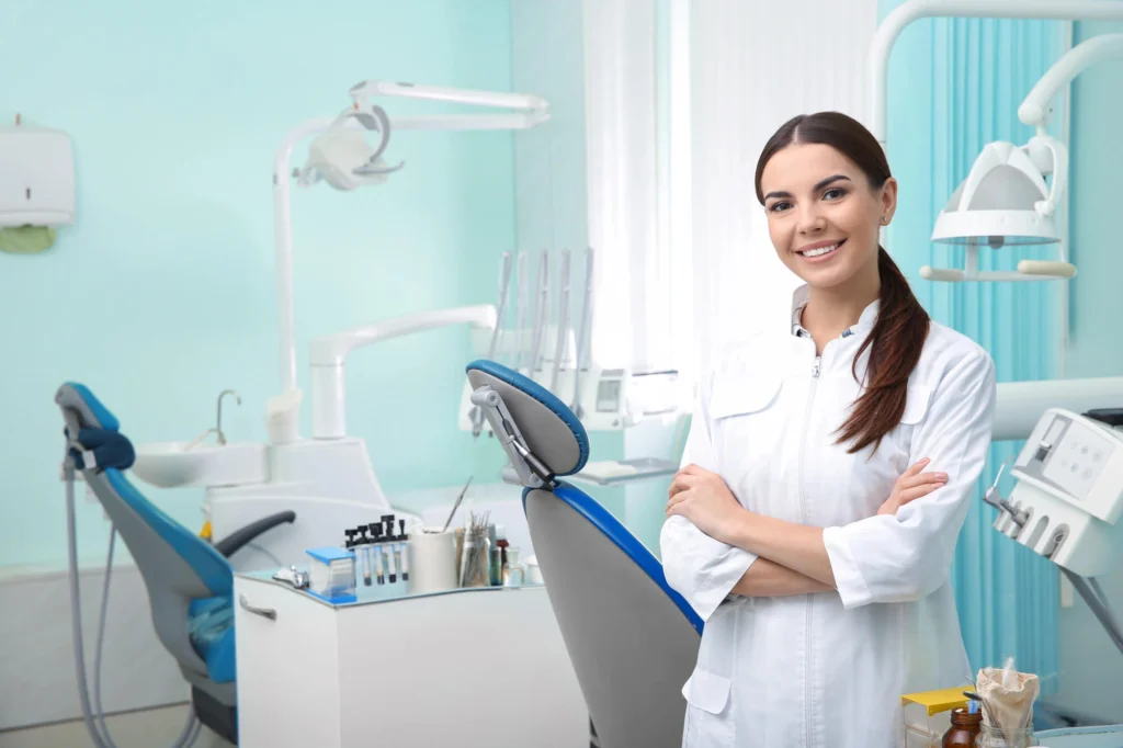 Young female dentist near me in white coat at workplace