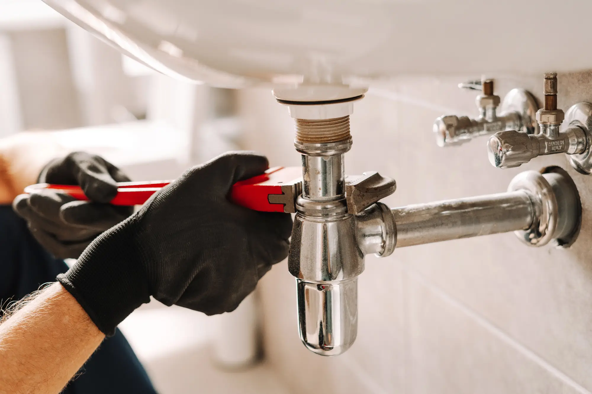 Re-drain Glendale CA plumber fixing sink pipe with wrench