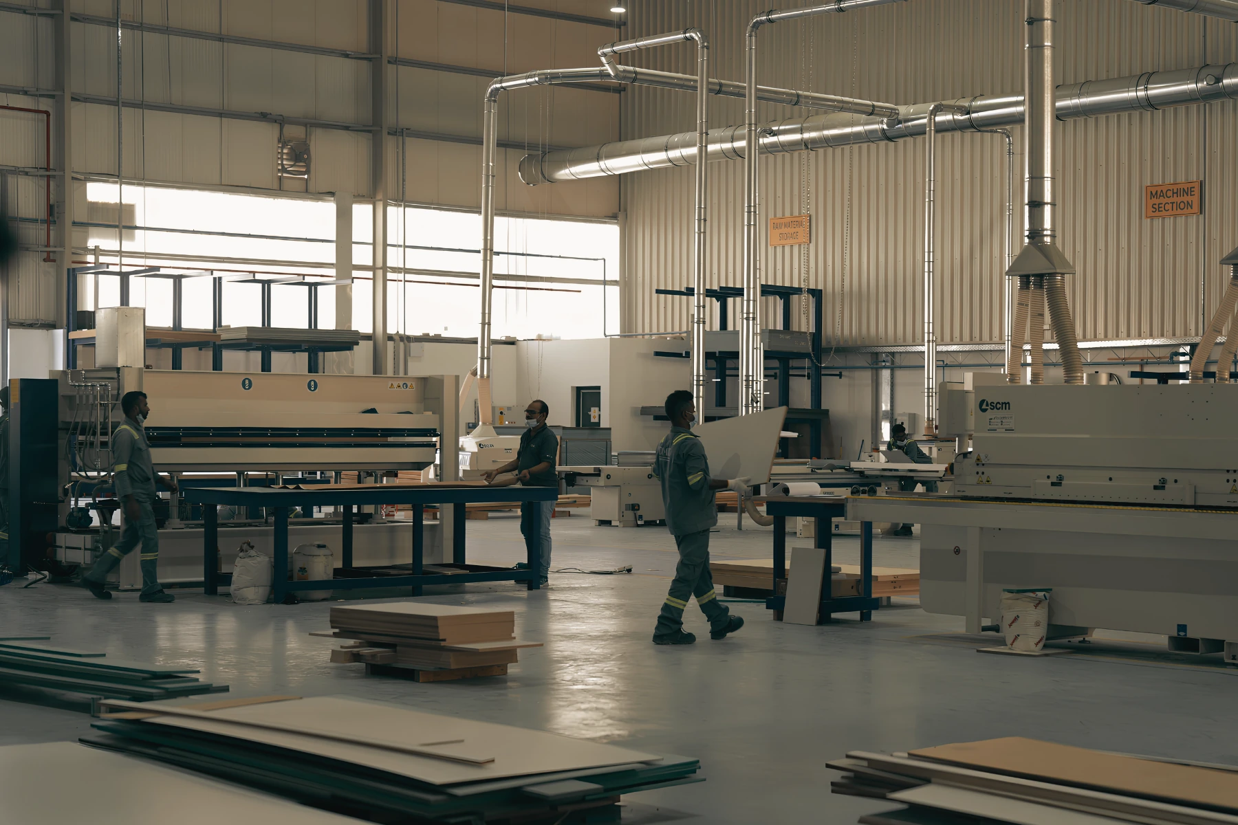 The DMDC woodworks floor — the machine section with panel saw and edgebander, joiners moving sheet material