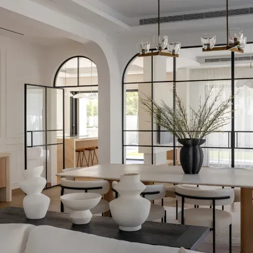 A dining room with arched steel-framed glazing onto the terrace