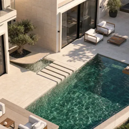 A pool seen from above, with a water feature and a mature olive tree on the terrace