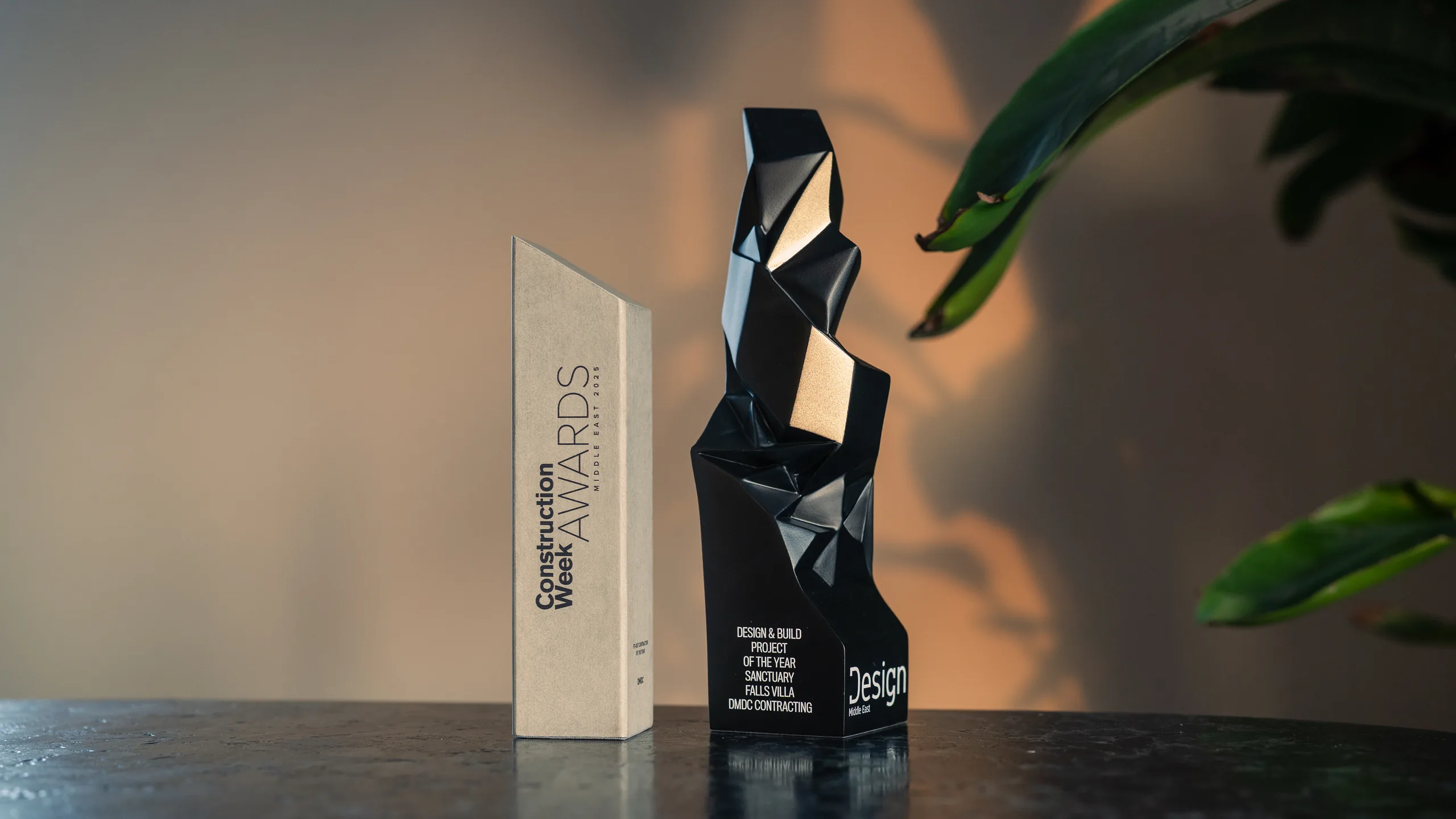 The Construction Week Awards Middle East 2025 trophy beside the Design Middle East Design and Build Project of the Year award for Sanctuary Falls Villa