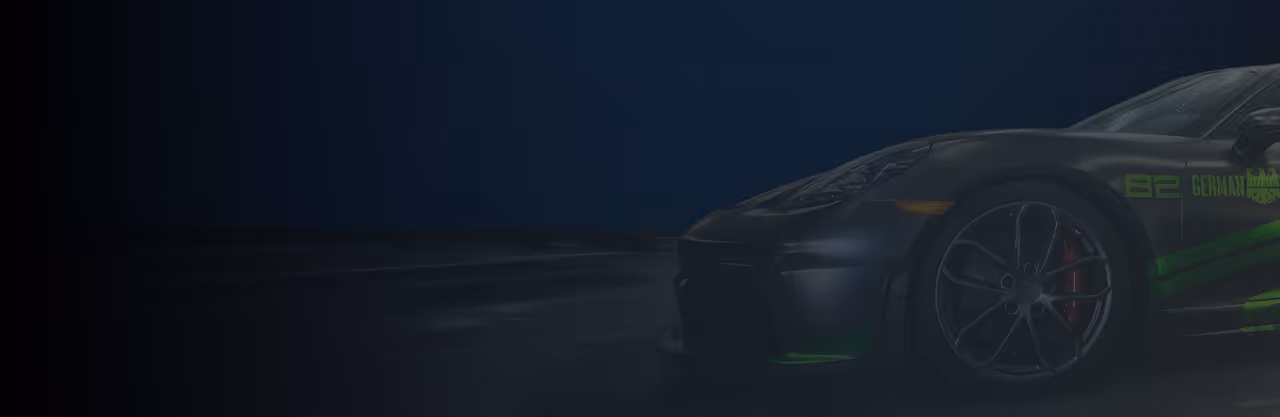 Gray sports car with green accents and decals parked on shiny concrete floor indoors.