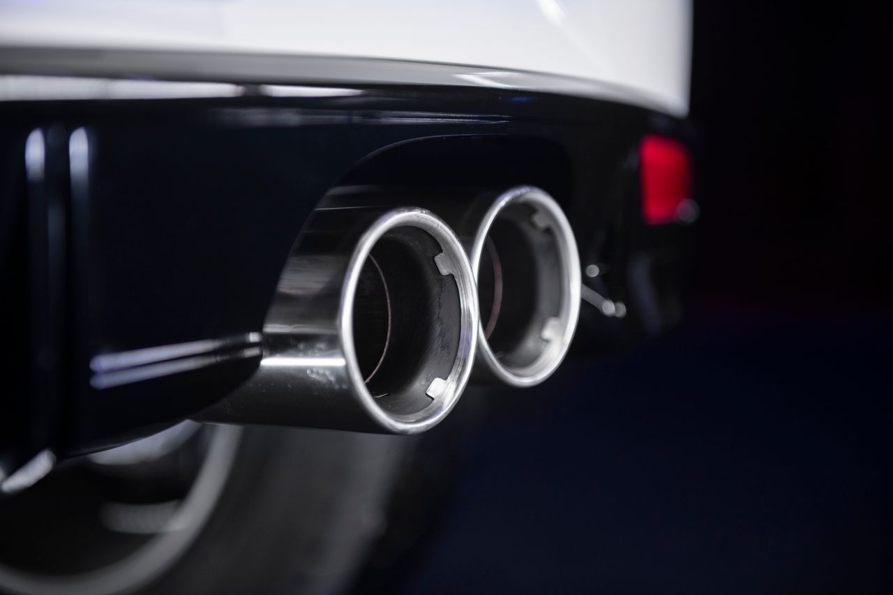 Close-up of a car's dual chrome exhaust pipes at the rear bumper.