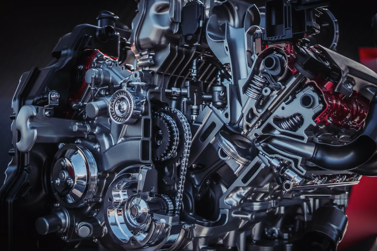Close-up of a detailed car engine cutaway showing internal gears, chains, and piston components.
