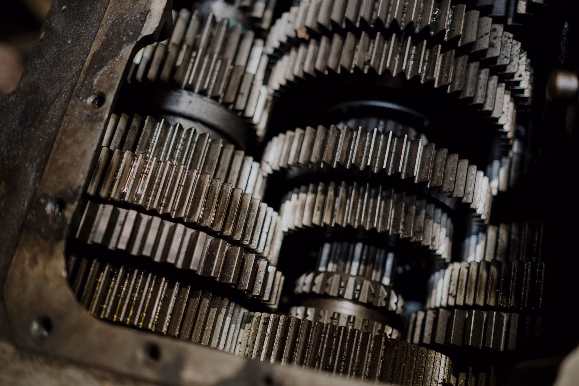 Close-up of metal gears inside a mechanical gearbox showing detailed teeth and shafts.