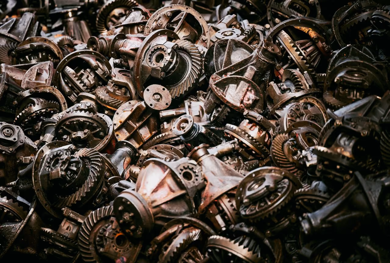 Pile of rusty mechanical gears and metal parts closely stacked together.