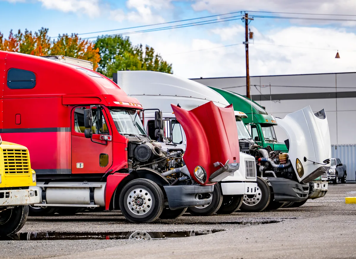 Semi trucks with hoods open for maintenance