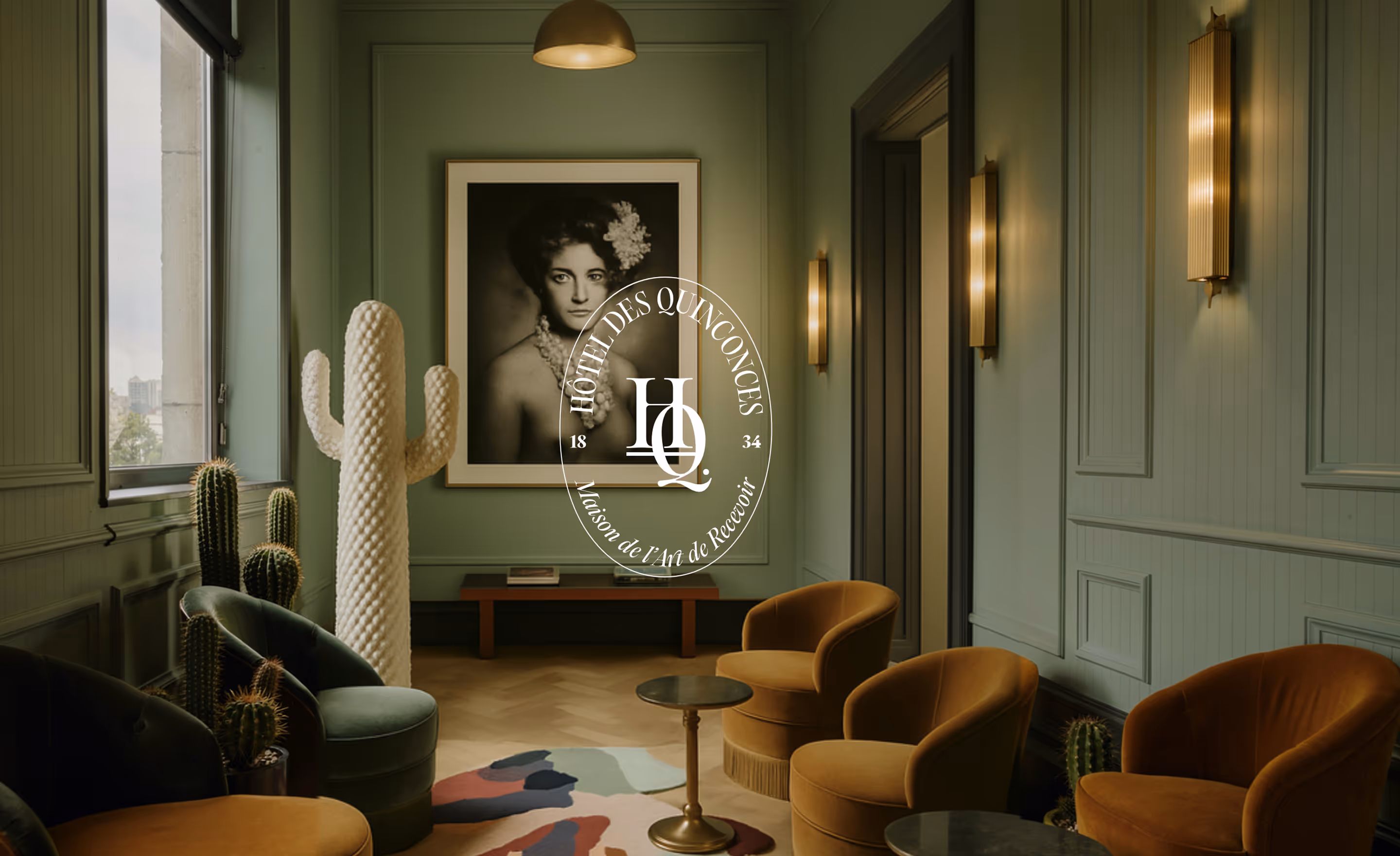 Salon vert avec fauteuils moutarde et logo Hôtel des Quinconces, projet Hospitality Family.
