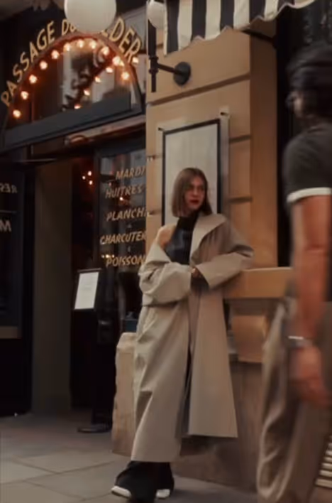 Femme en trench-coat devant une façade de restaurant parisienne, signée Hospitality Family.