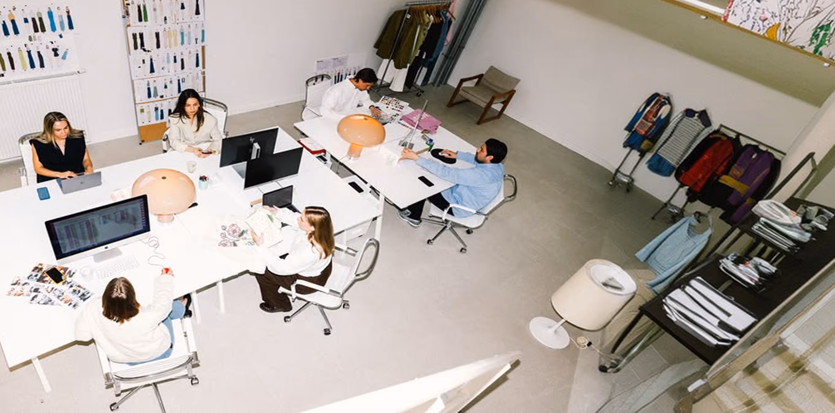 Vue en plongée d'un studio de création avec équipe au travail, ambiance signée Hospitality Family.
