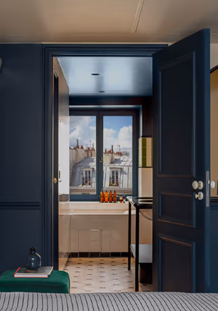 Salle de bain vue depuis une chambre avec vue sur les toits parisiens, signée Hospitality Family.