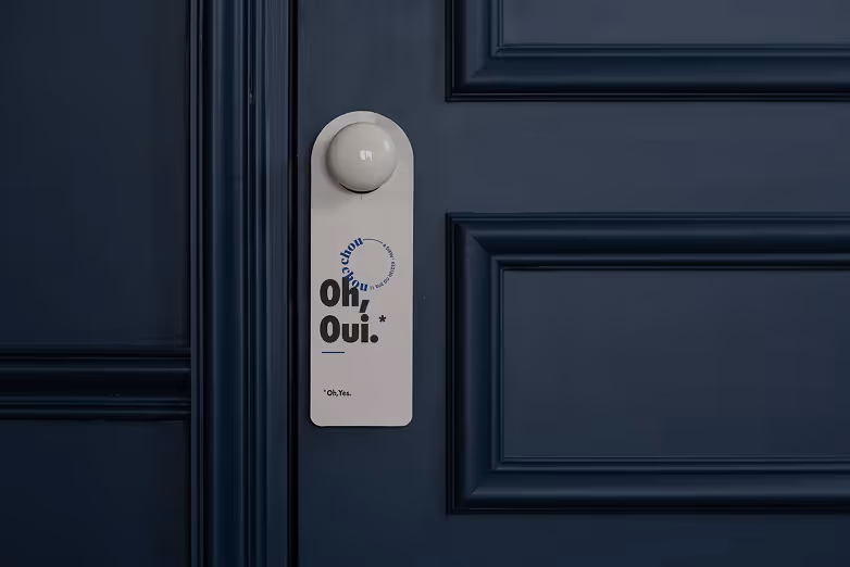 Pancarte de porte « Oh, Oui » sur une porte bleu marine, projet Chouchou par Hospitality Family.