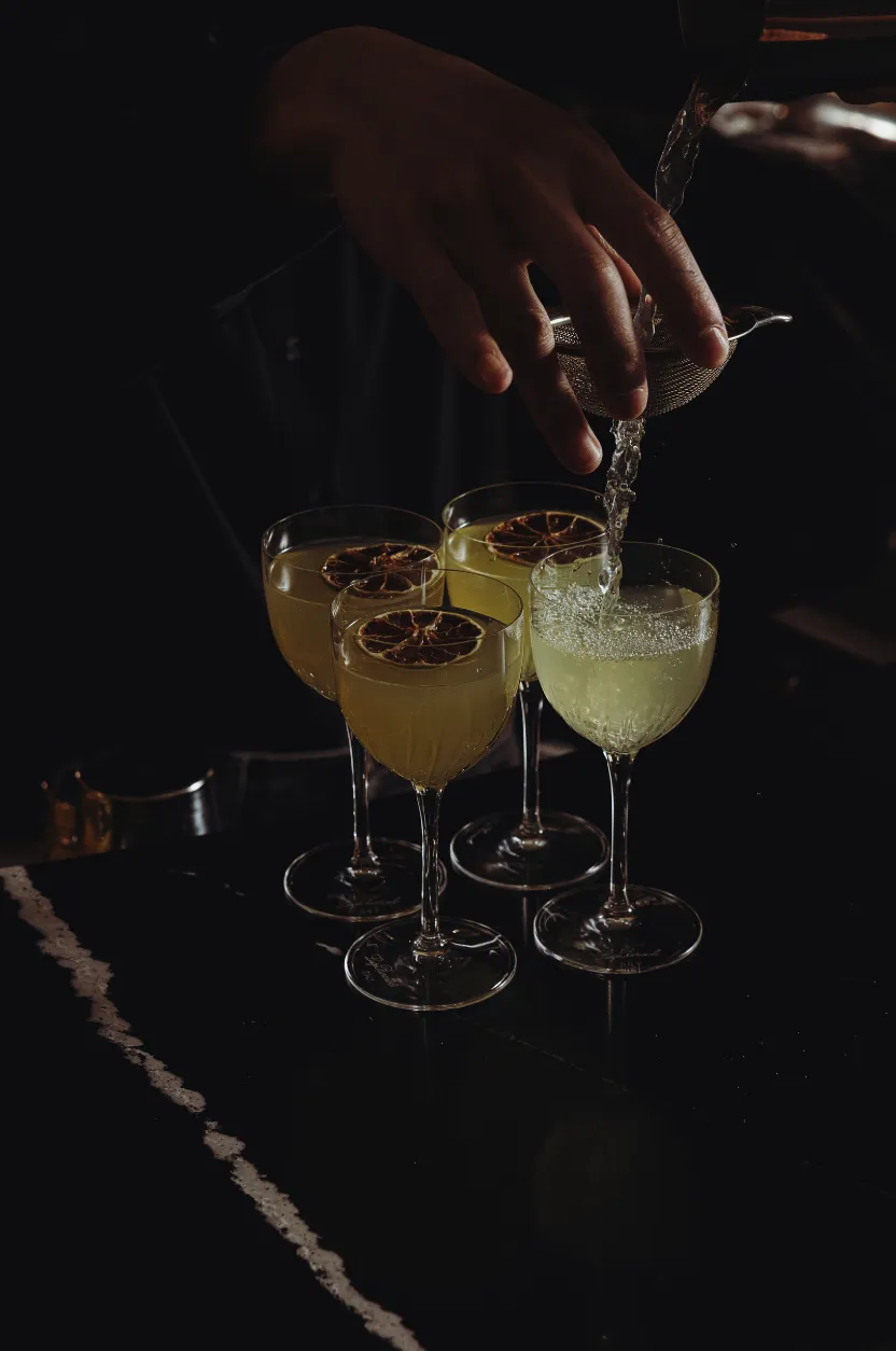 Cocktails dressés au bar avec finition à la passoire signés Hospitality Family.