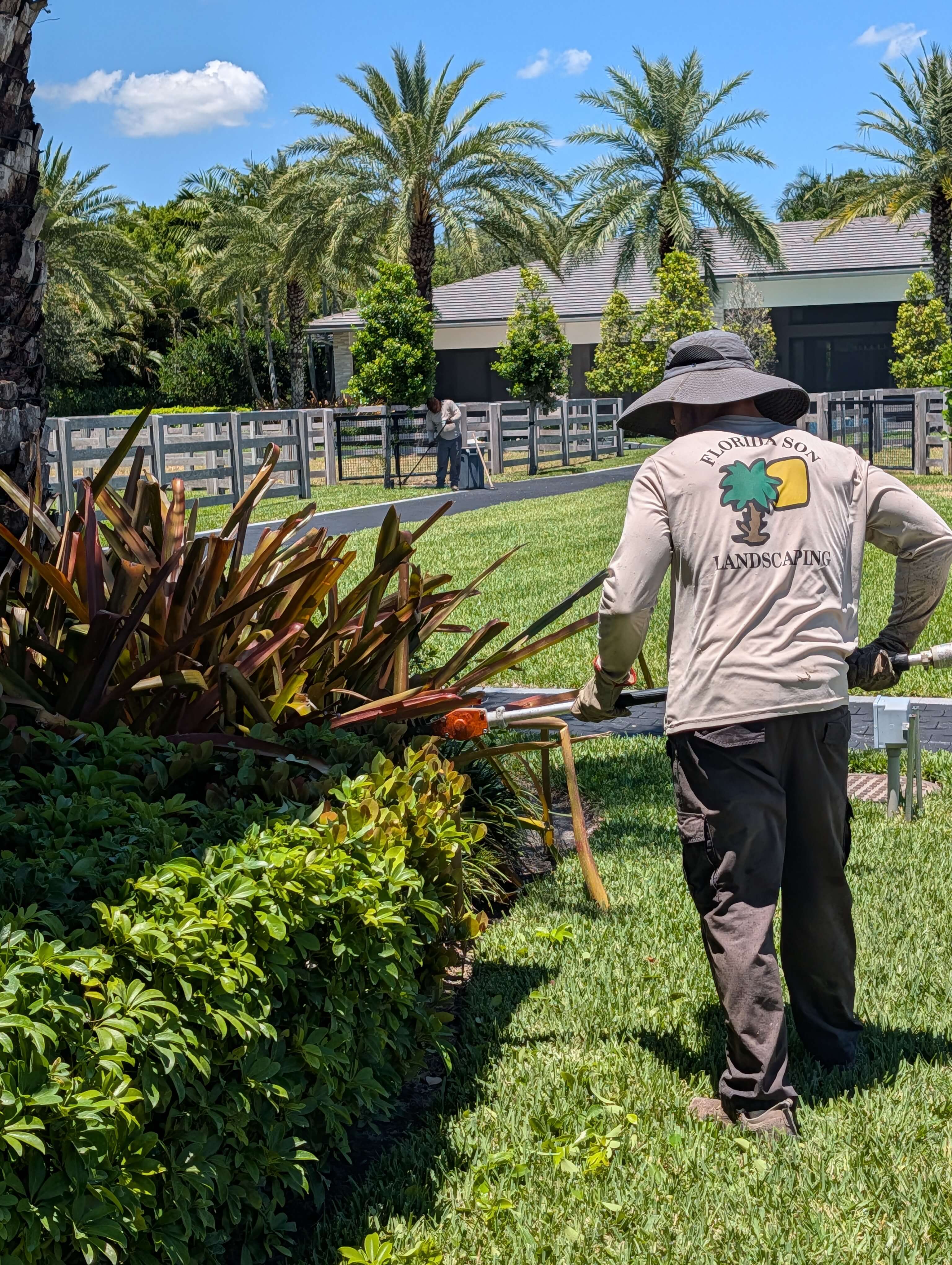 Florida Son Landscaping crew member maintaining a South Florida estate property