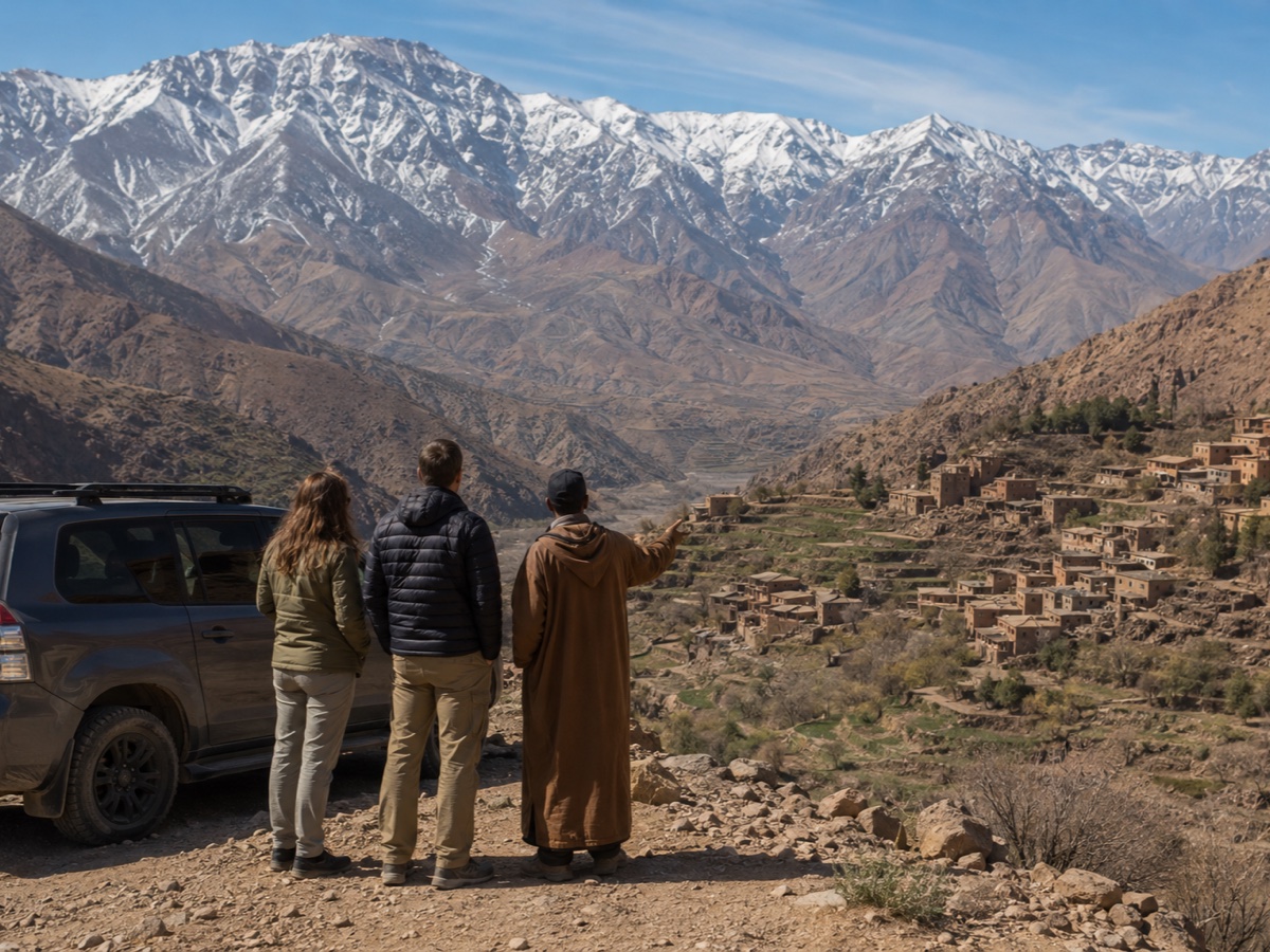 Travelers and guide overlooking a village in Morocco's High Atlas
