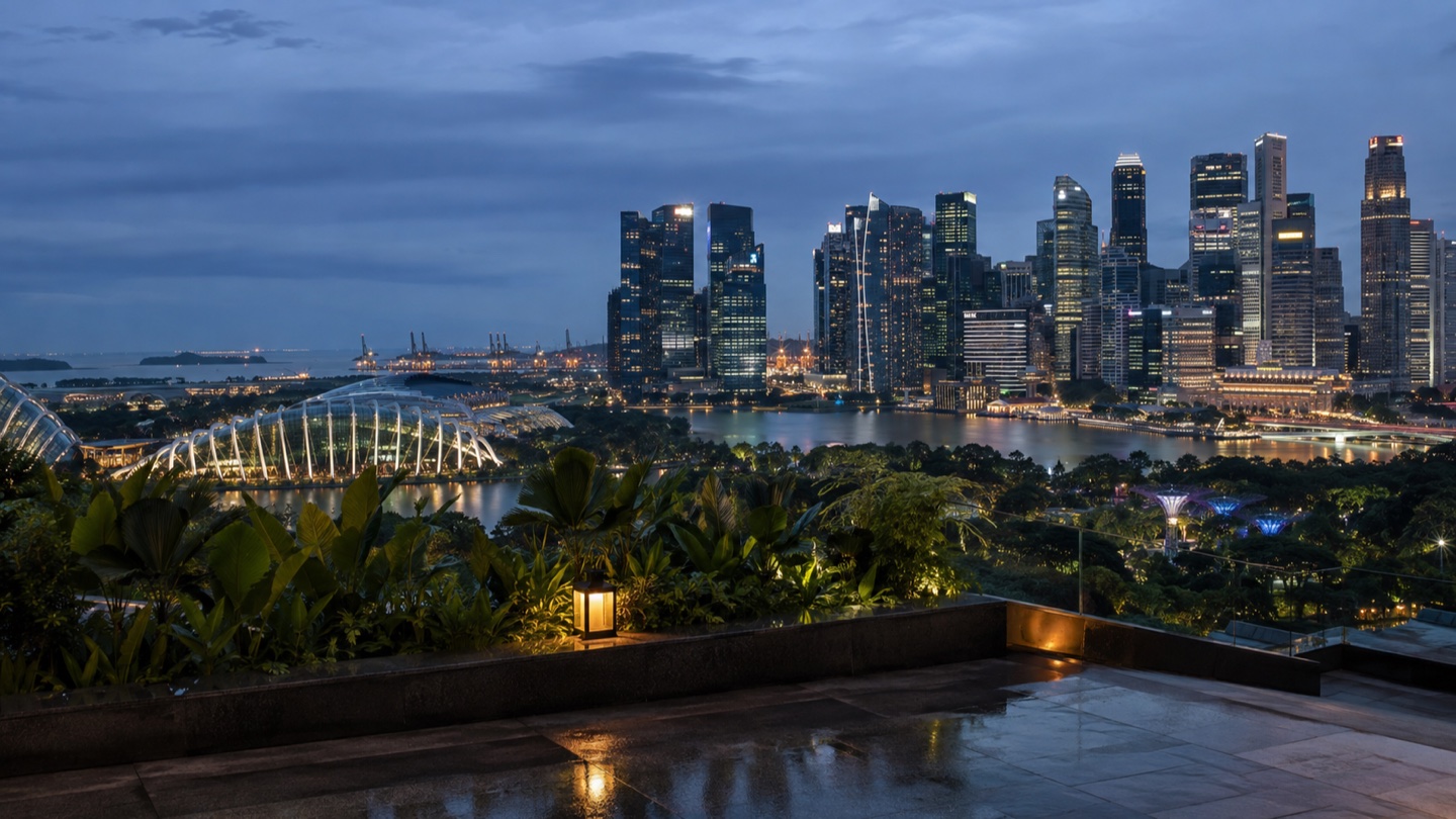 Singapore's Marina Bay skyline beyond a tropical rooftop terrace at blue hour