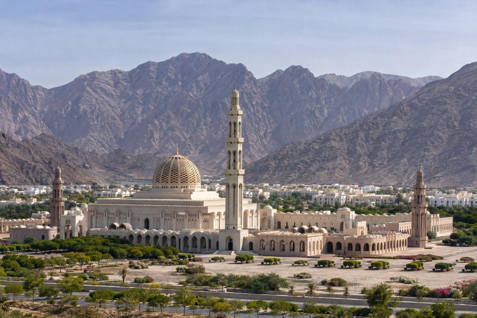 The Sultan Qaboos Grand Mosque and its minaret against the dry mountains behind Muscat