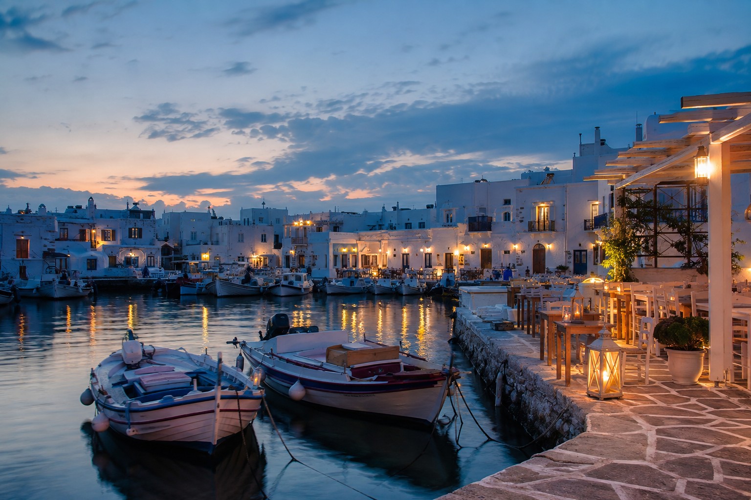 Whitewashed cubes and small fishing boats in Naoussa harbour on Paros at blue hour
