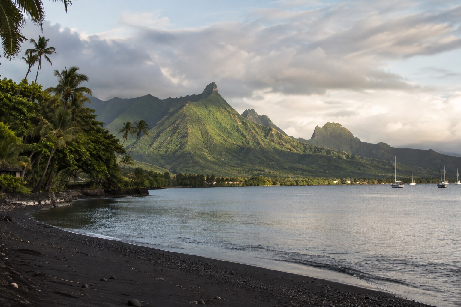 Volcanic green ridges falling to a turquoise lagoon on the coast of Tahiti