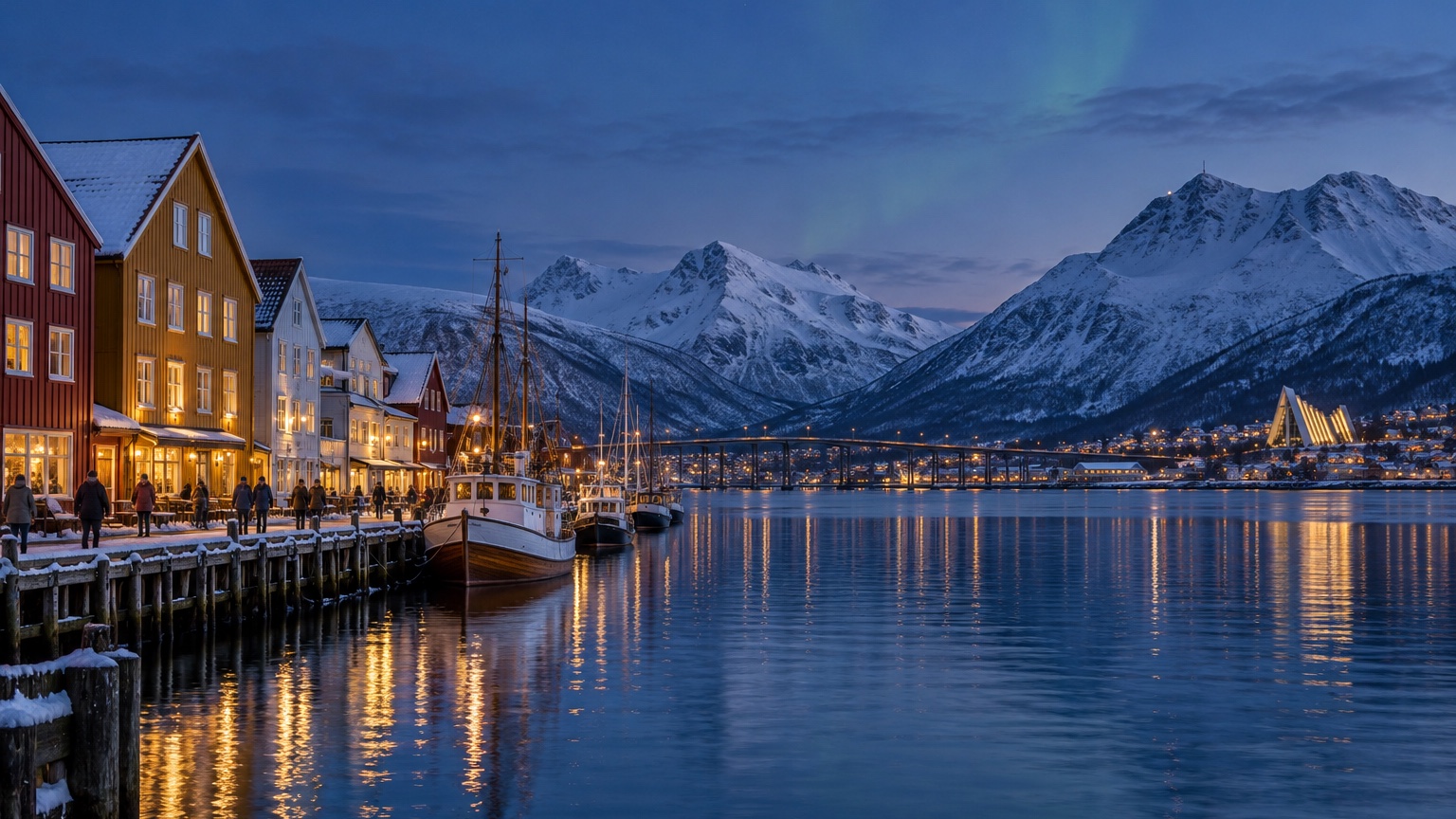 Tromsø harbor with colorful buildings, snowy mountains, and winter evening light