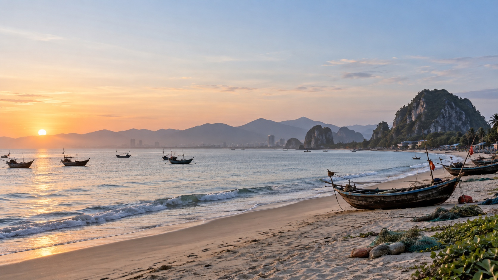 Quiet Da Nang beach at dawn with fishing boats and green hills beyond