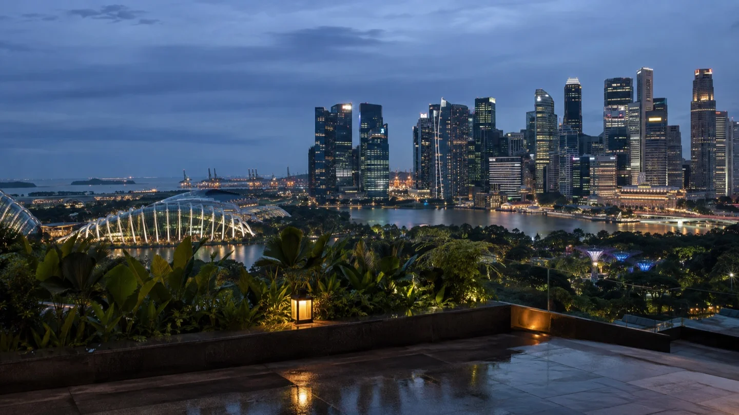 Singapore's Marina Bay skyline beyond a tropical rooftop terrace at blue hour