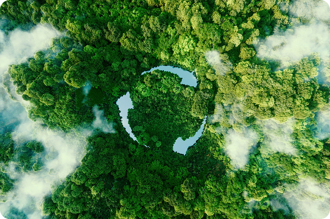 Aerial view of a dense green forest with a circular clearing shaped like a recycling symbol.