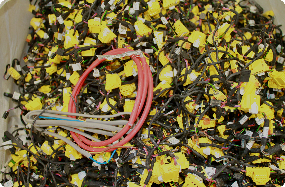 Pile of electrical wires with yellow connectors and a group of red and gray cables on top.