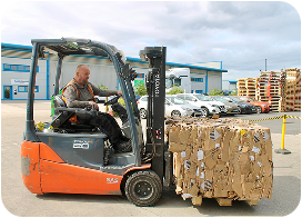 Bins filled with black BMW steering wheel airbag modules in a warehouse setting.