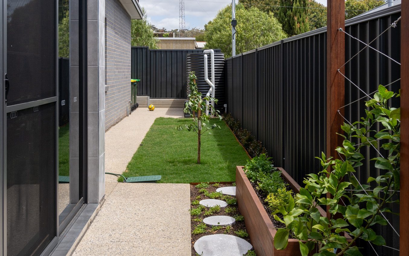 Exposed aggregate concrete path and stepping stones along a planted side garden, Catcrete, Adelaide
