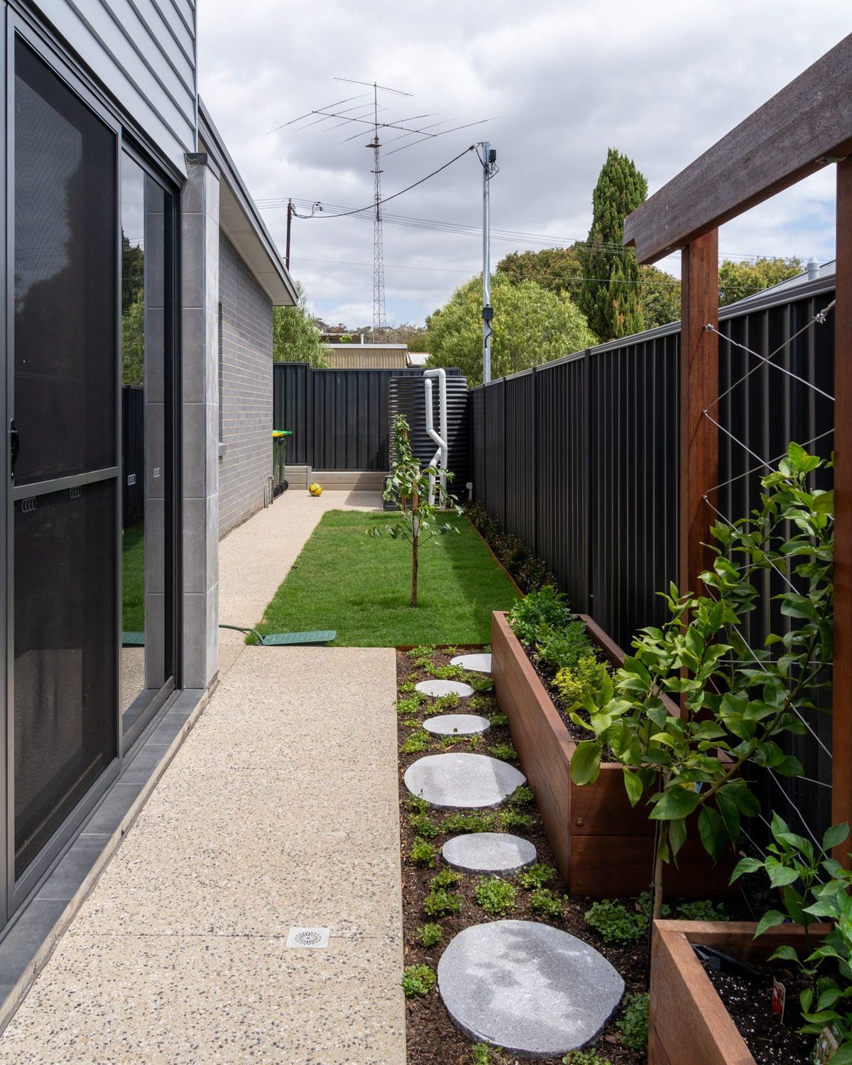 Exposed aggregate concrete path and stepping stones along a planted side garden, Catcrete, Adelaide