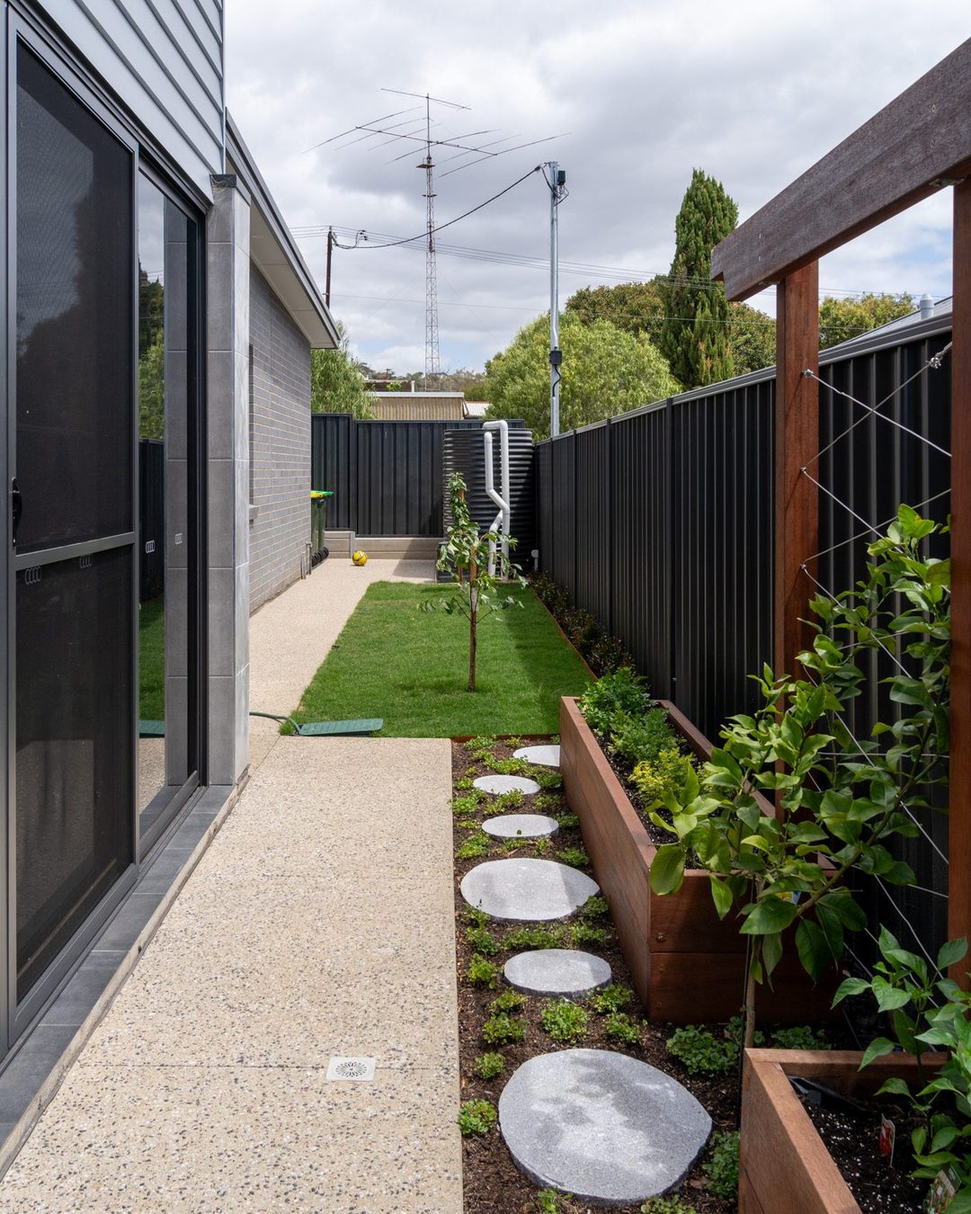 Exposed aggregate concrete path and stepping stones along a planted side garden, Catcrete, Adelaide