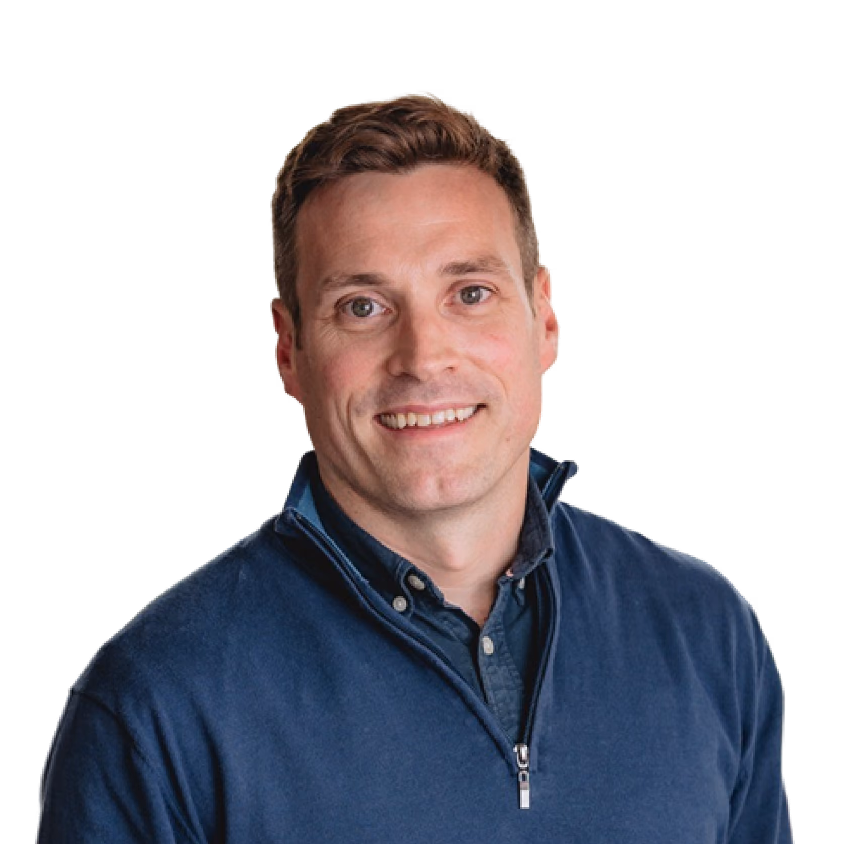 Smiling man with short brown hair wearing a blue zip-up sweater over a buttoned shirt.