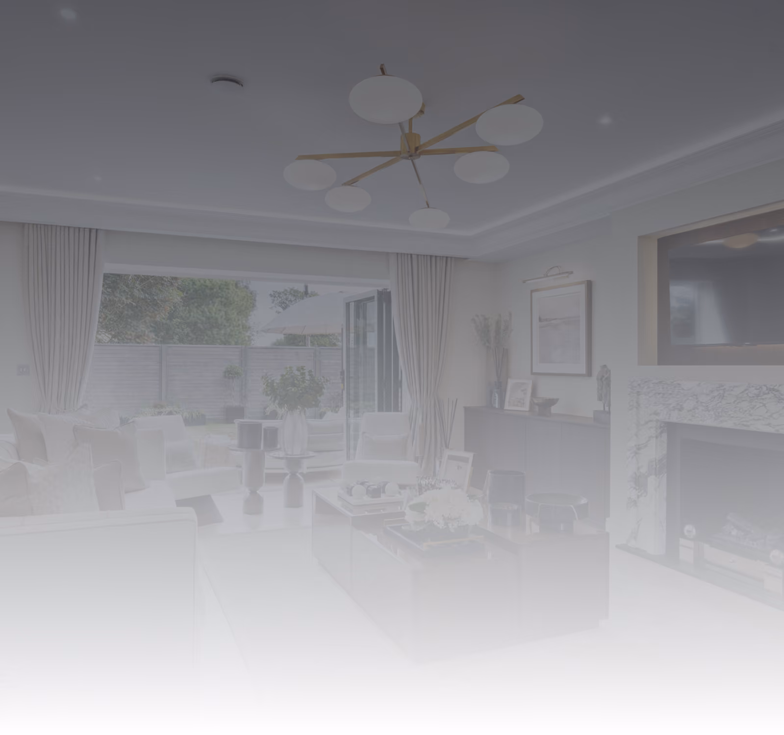 Modern living room with large windows, white furniture, coffee table, and a marble fireplace.