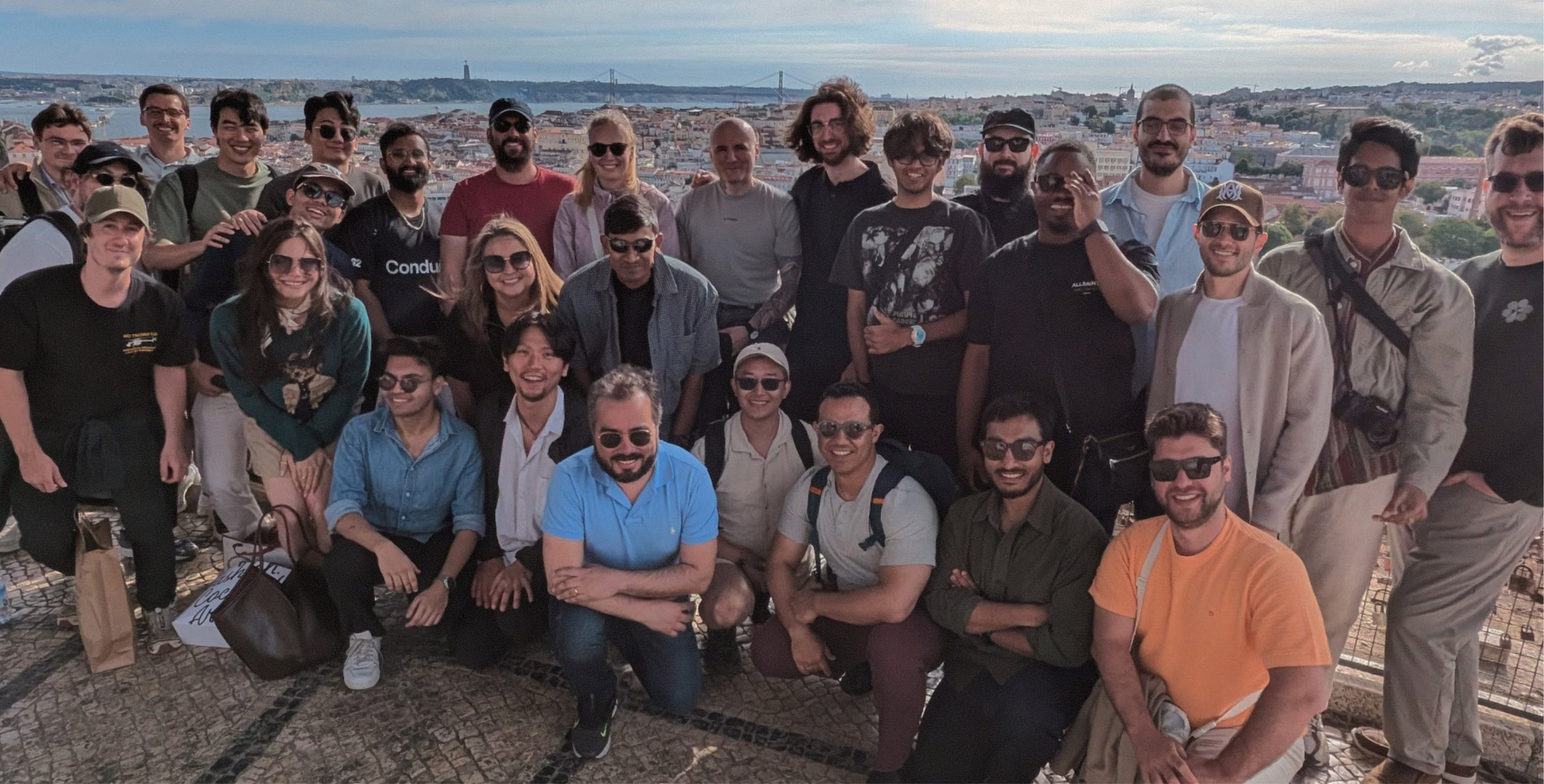 The Conduit team gathered outdoors on a hillside overlooking Lisbon