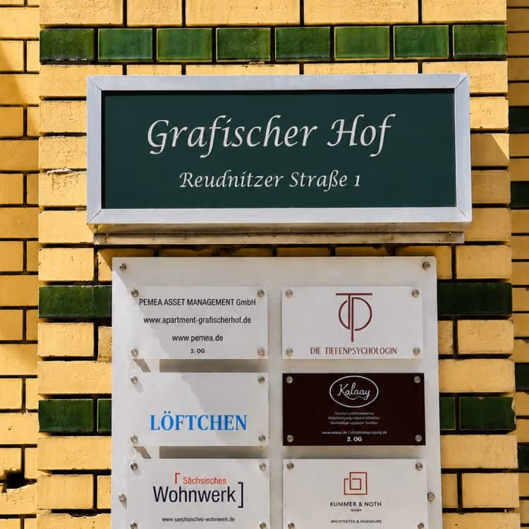 Hinweisschild am Grafischen Hof in der Reudnitzer Straße mit Mieterübersicht, darunter Die Tiefenpsychologin
