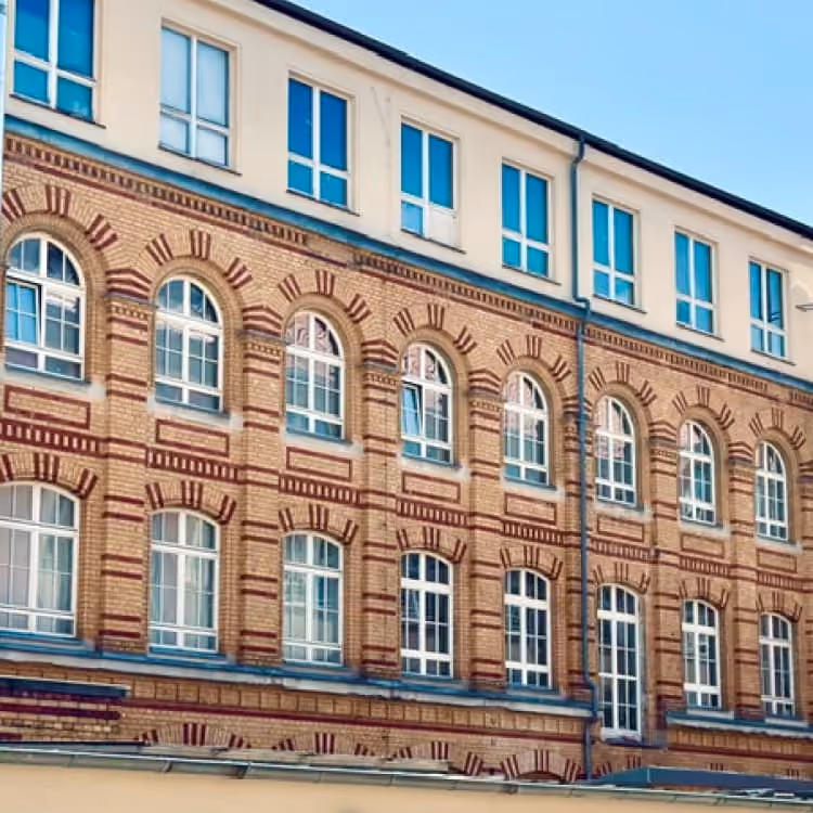 Backsteinfassade des Grafischen Hofs mit historischen Sprossenfenstern