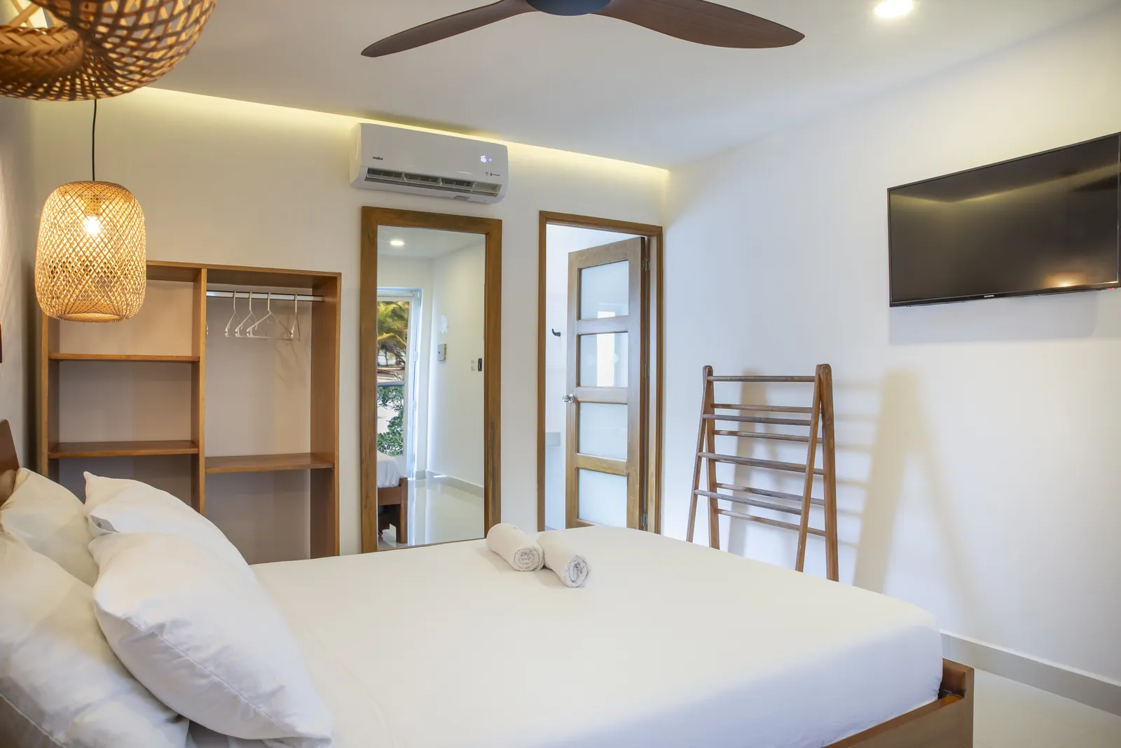 Habitación Doble Estándar con clóset abierto, TV y espejo de cuerpo entero — Hotel Camino Palmero, Coveñas