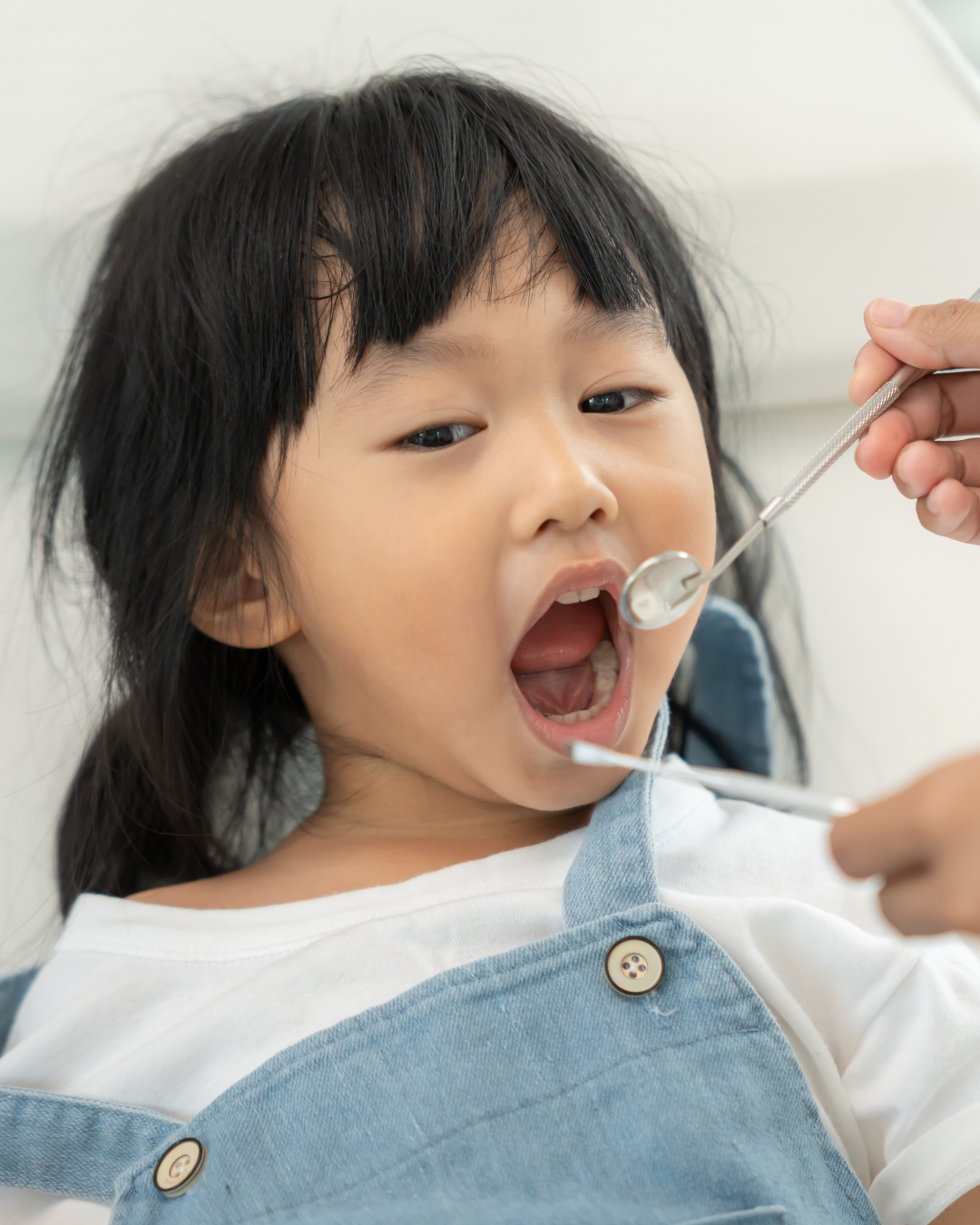 Child with pigtails in dentist's chair