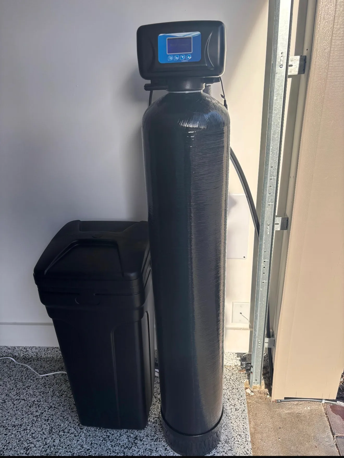 Whole-home water softener installed in a garage
