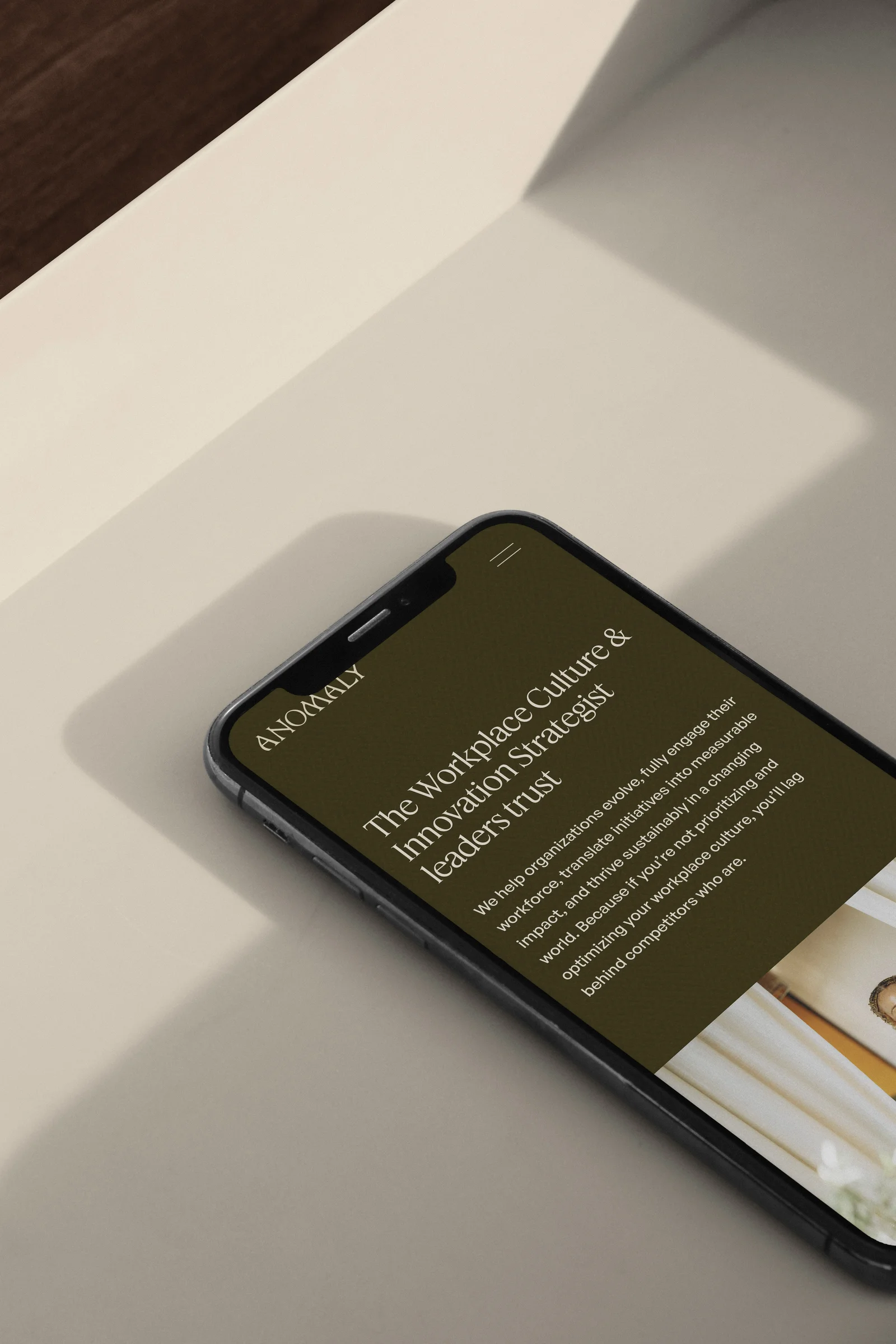 Anomaly website shown on an iPhone mockup