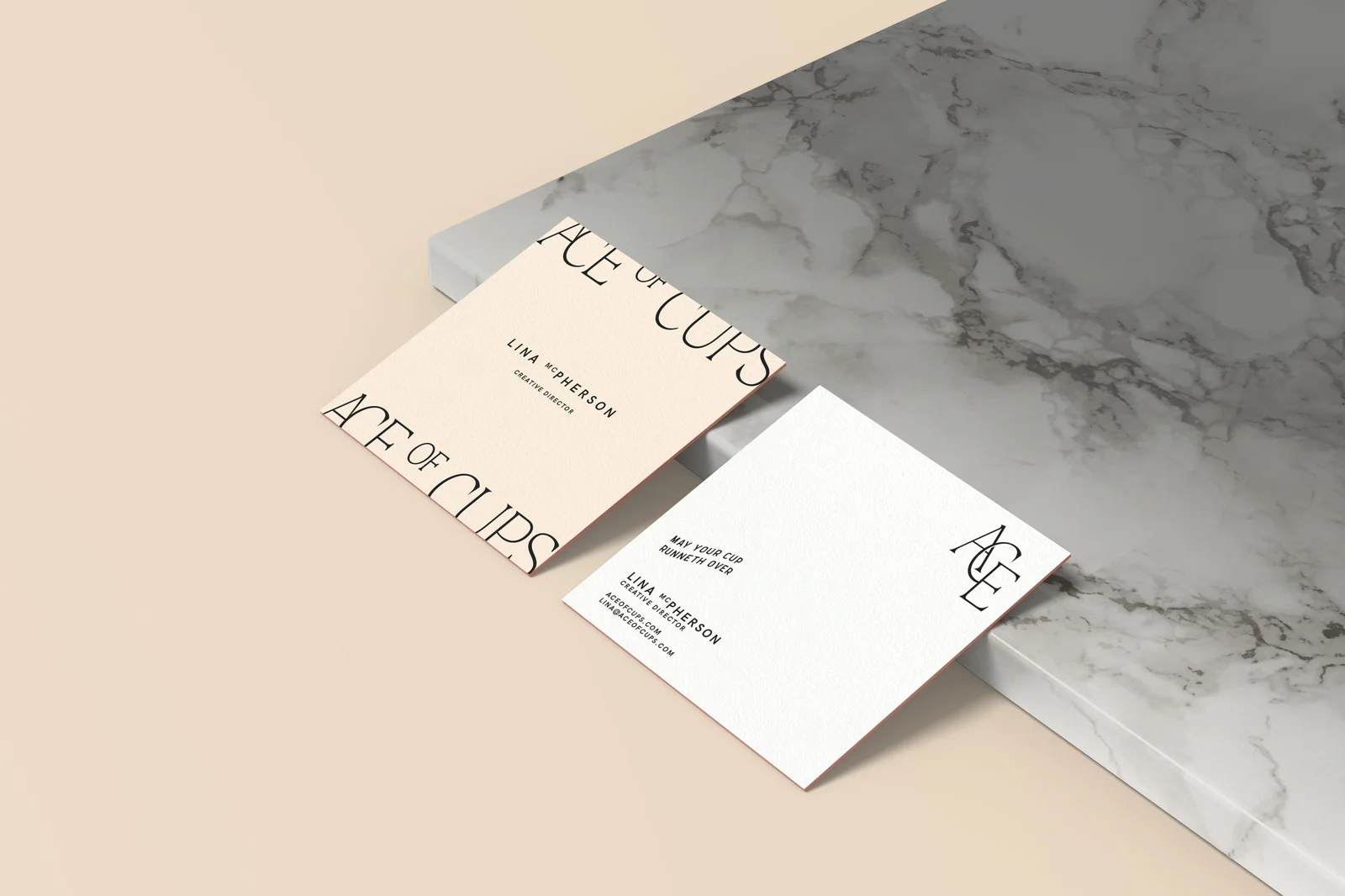Ace of Cups square business cards for Creative Director Lina McPherson displayed on a marble surface, showing front and back designs