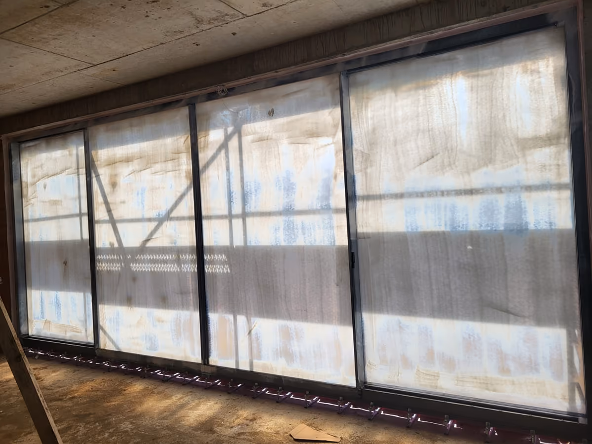 Large window panels covered with protective peelable coating in a building under construction.