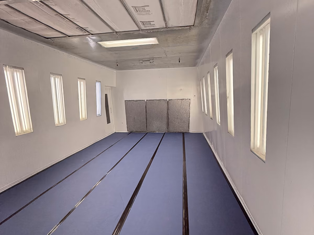 Empty indoor shooting range with blue floor lanes and white walls.