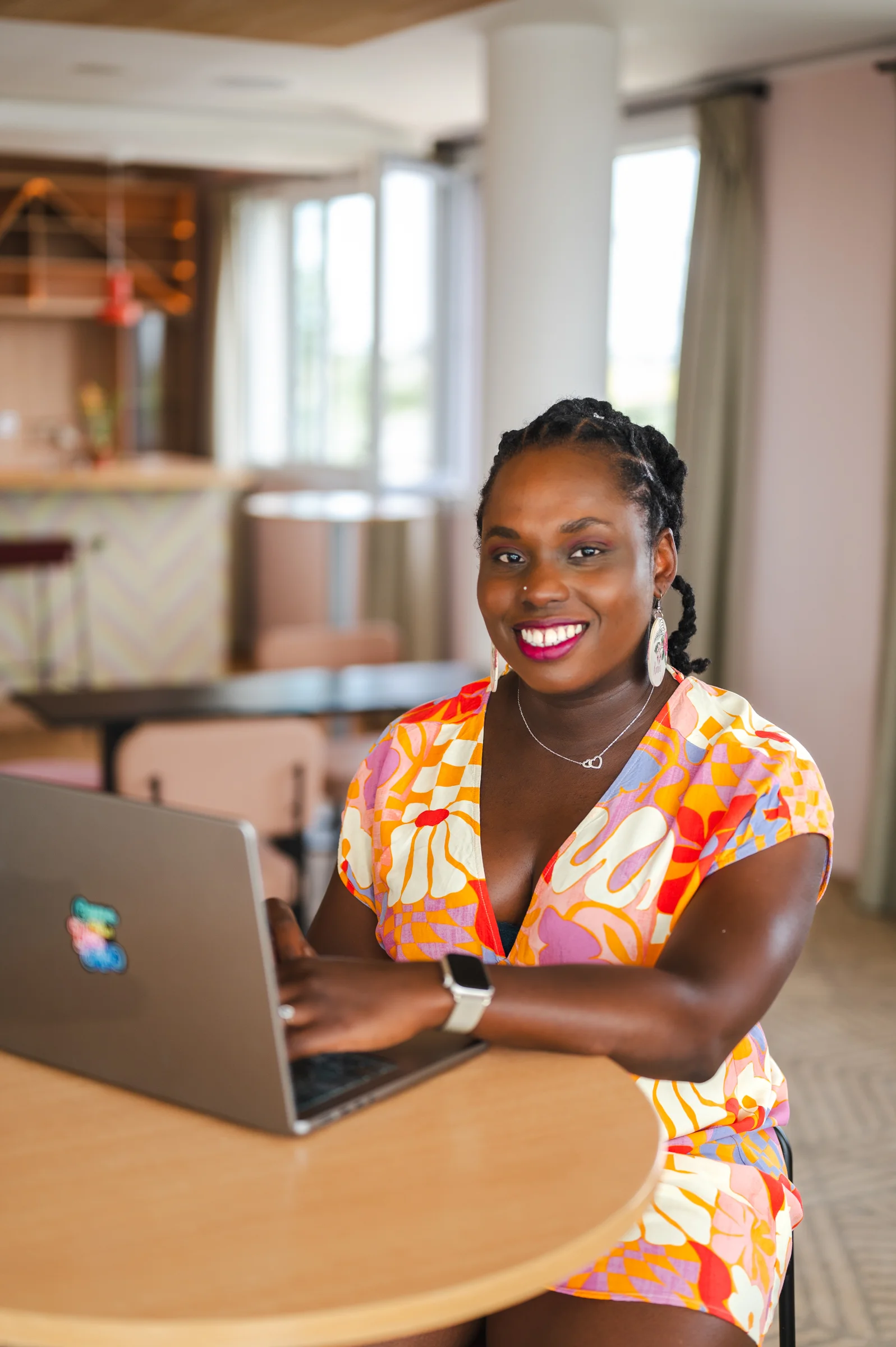 Karine, webdesigner freelance, souriante devant son ordinateur portable dans un espace de travail lumineux à Bordeaux.
