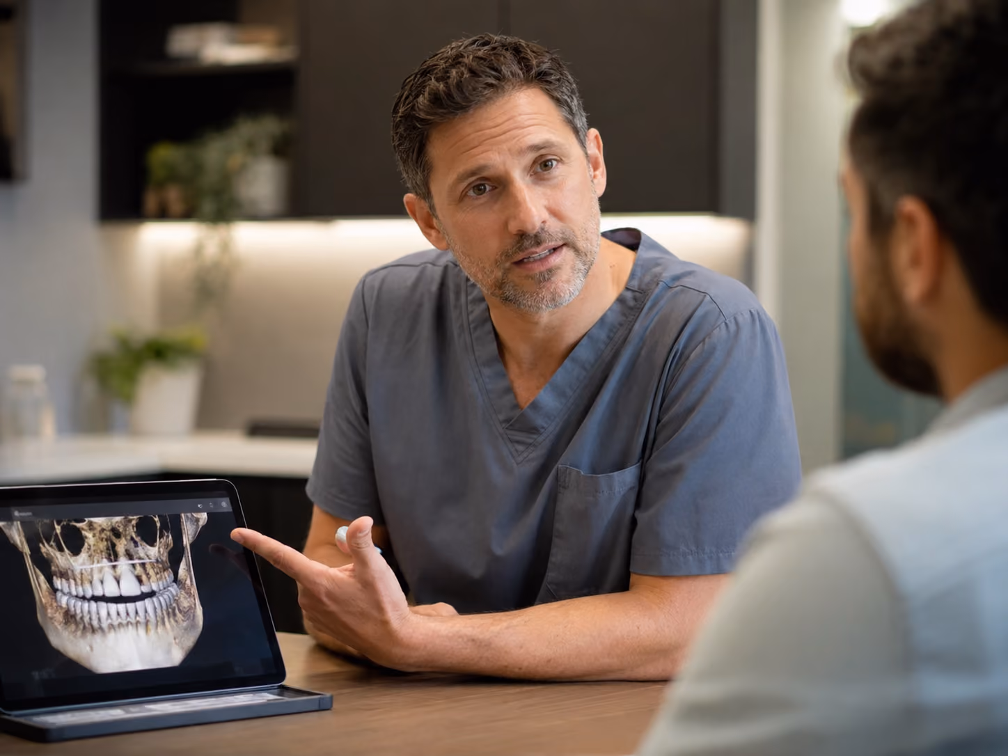 Doctor reviewing a 3D cone beam CT scan with a patient during a full mouth implant consultation