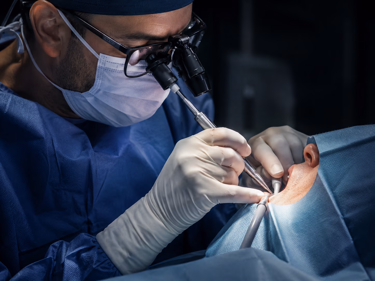 Oral surgeon placing dental implants in a sterile surgical operatory